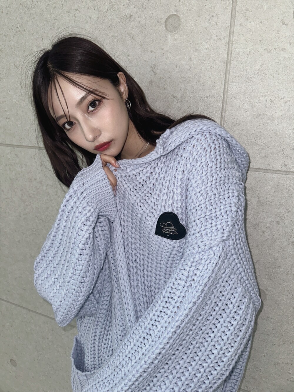 グレー系のスカート、ブルー系のニット/セーターを着用したレディースの秋コーディネートの3枚目の写真