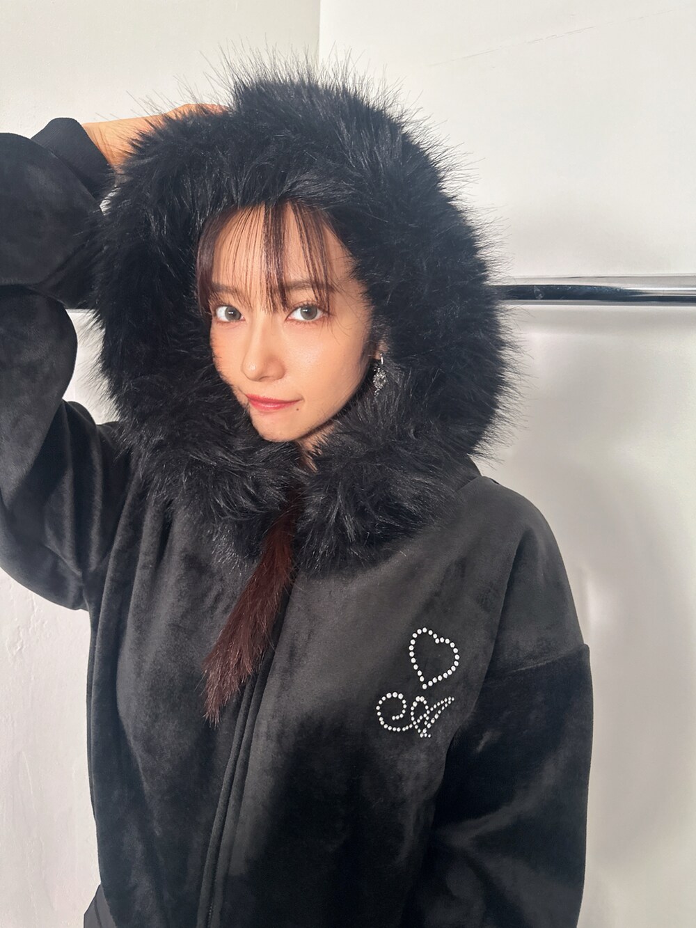 ブラック系のパーカー、ブラック系のスカートを着用したレディースの冬コーディネートの3枚目の写真