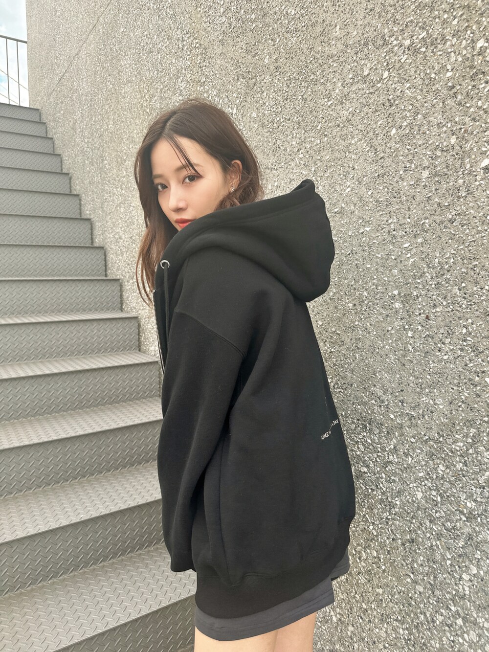 ブラック系のパーカーを着用したレディースの冬コーディネートの3枚目の写真