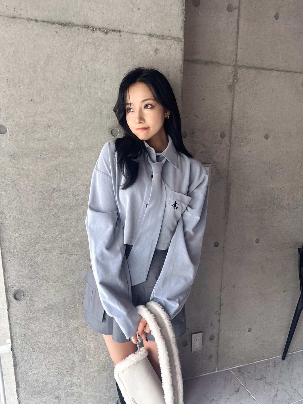 ブルー系のシャツ/ブラウス、グレー系のスカート、ホワイト系のショルダーバッグを着用したレディースの秋コーディネートの3枚目の写真