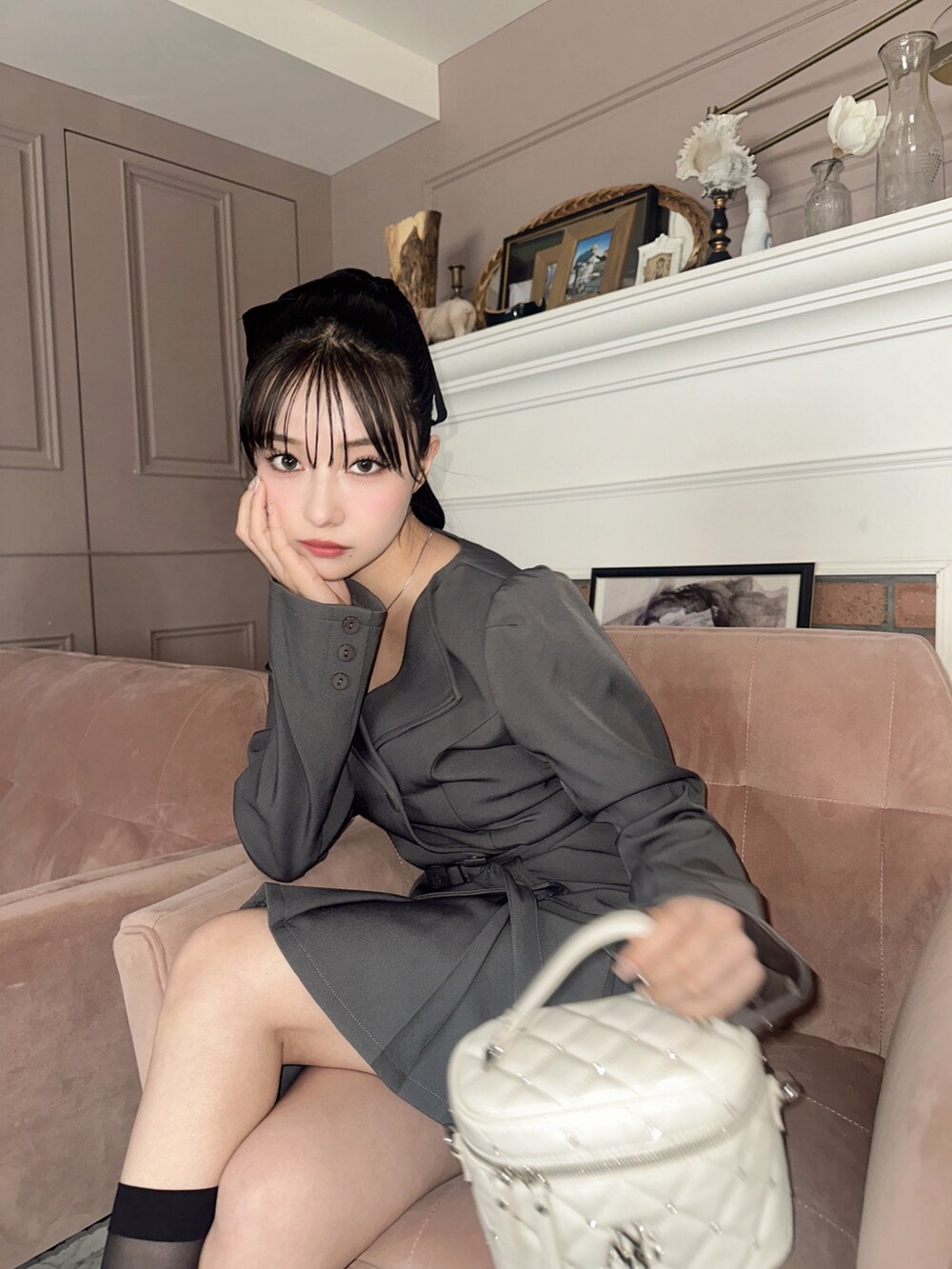 グレー系のワンピース、ホワイト系のショルダーバッグを着用したレディースの春コーディネートの2枚目の写真