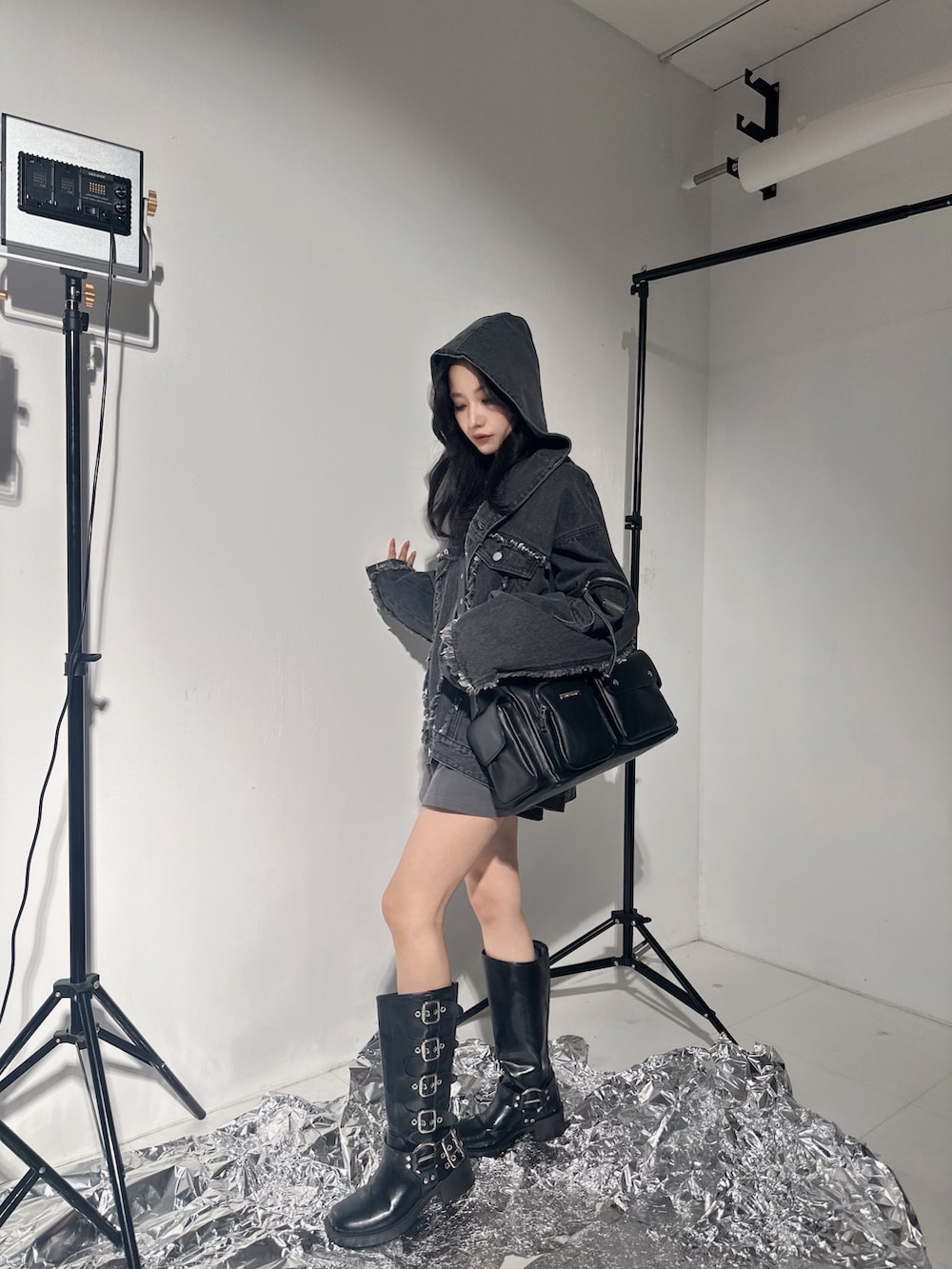 ブラック系のデニムジャケット、ブラック系のメッセンジャーバッグ、グレー系のTシャツ/カットソーを着用したレディースの冬コーディネートの2枚目の写真