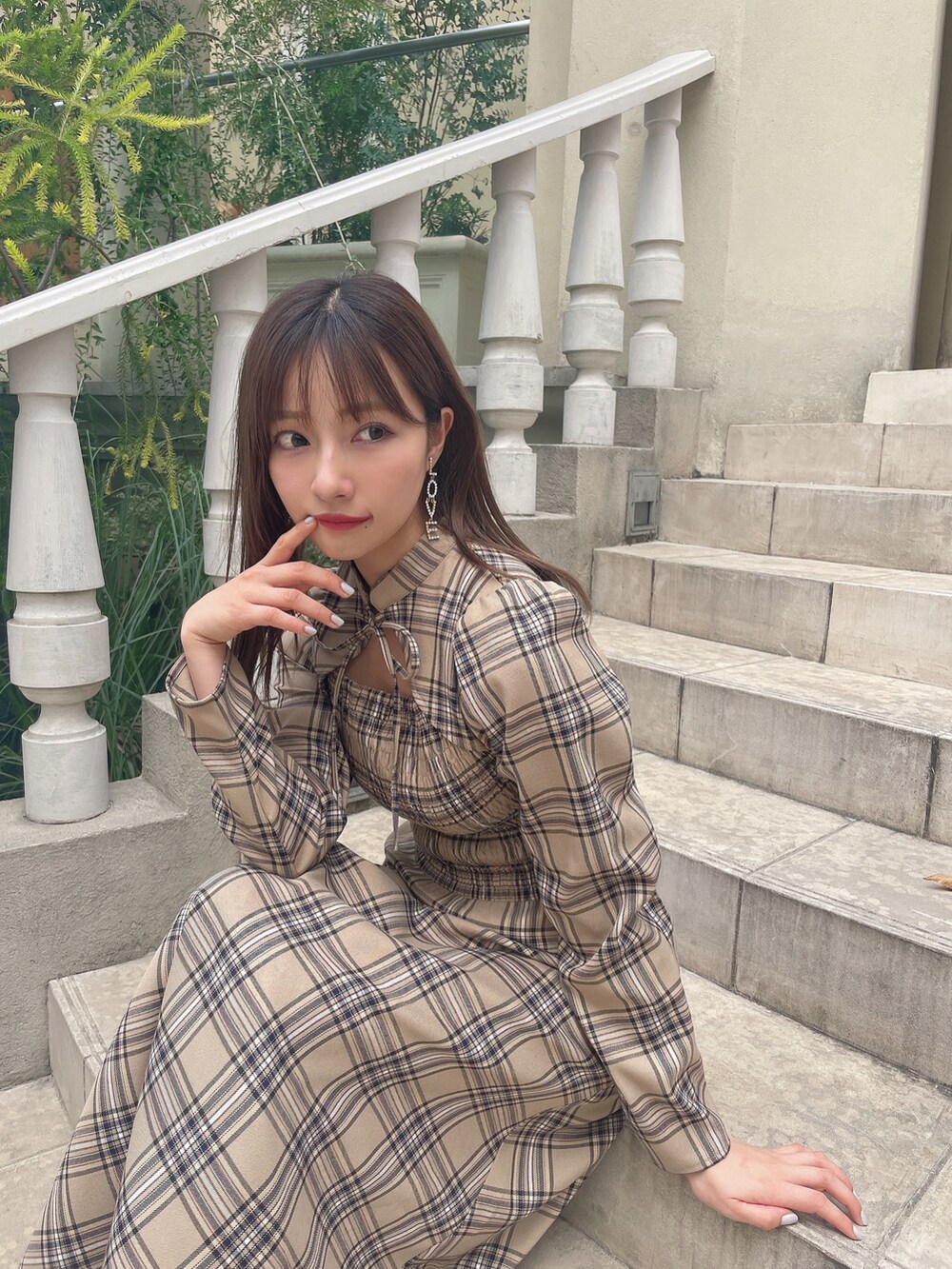 ベージュ系のワンピース、ブラック系のブーツを着用したレディースの冬コーディネートの2枚目の写真