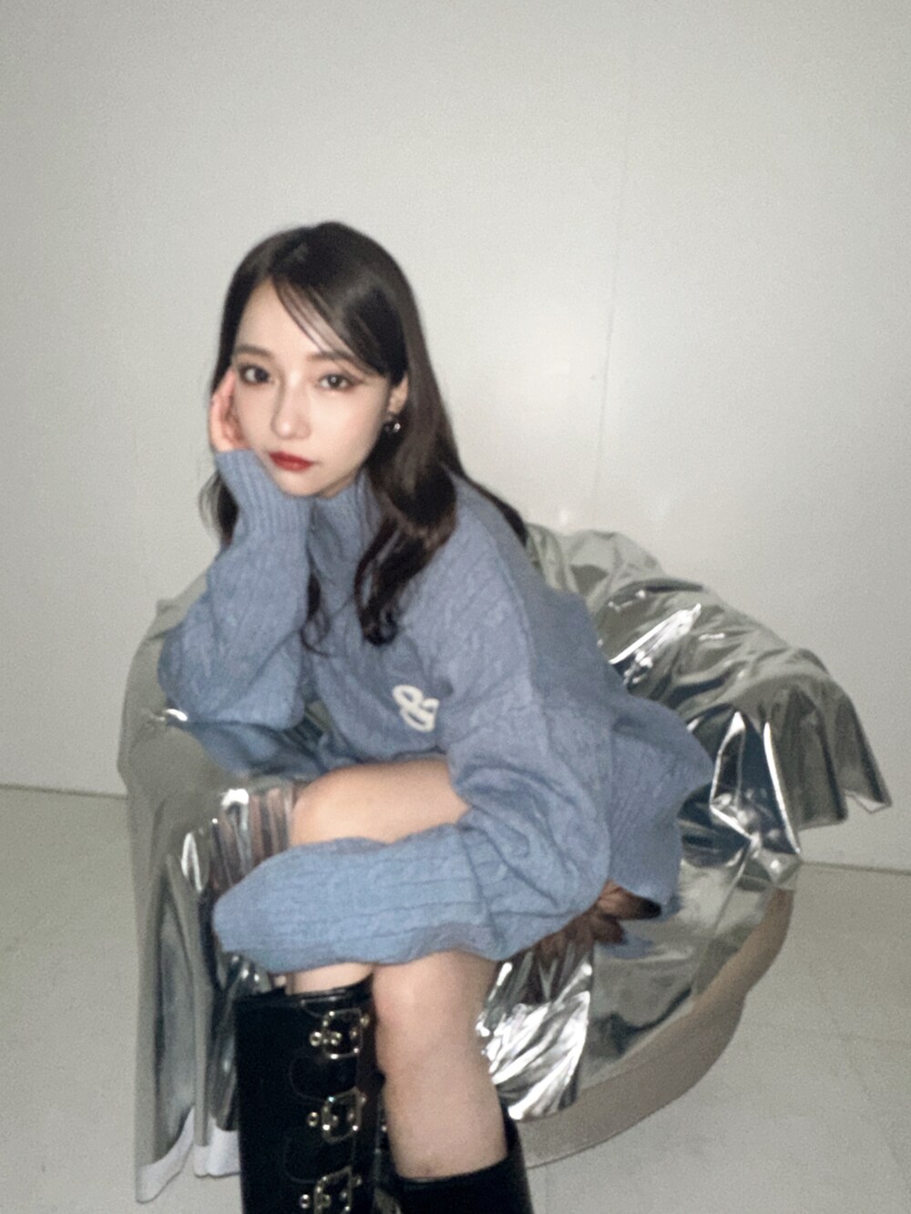 ブルー系のニット/セーターを着用したレディースの冬コーディネートの2枚目の写真