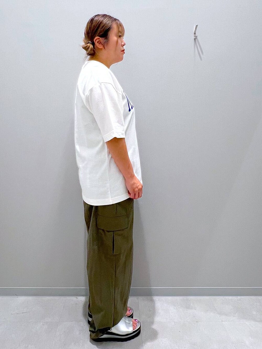 グリーン系のカーゴパンツ、ホワイト系のTシャツ/カットソーを着用したレディースの夏コーディネートの4枚目の写真