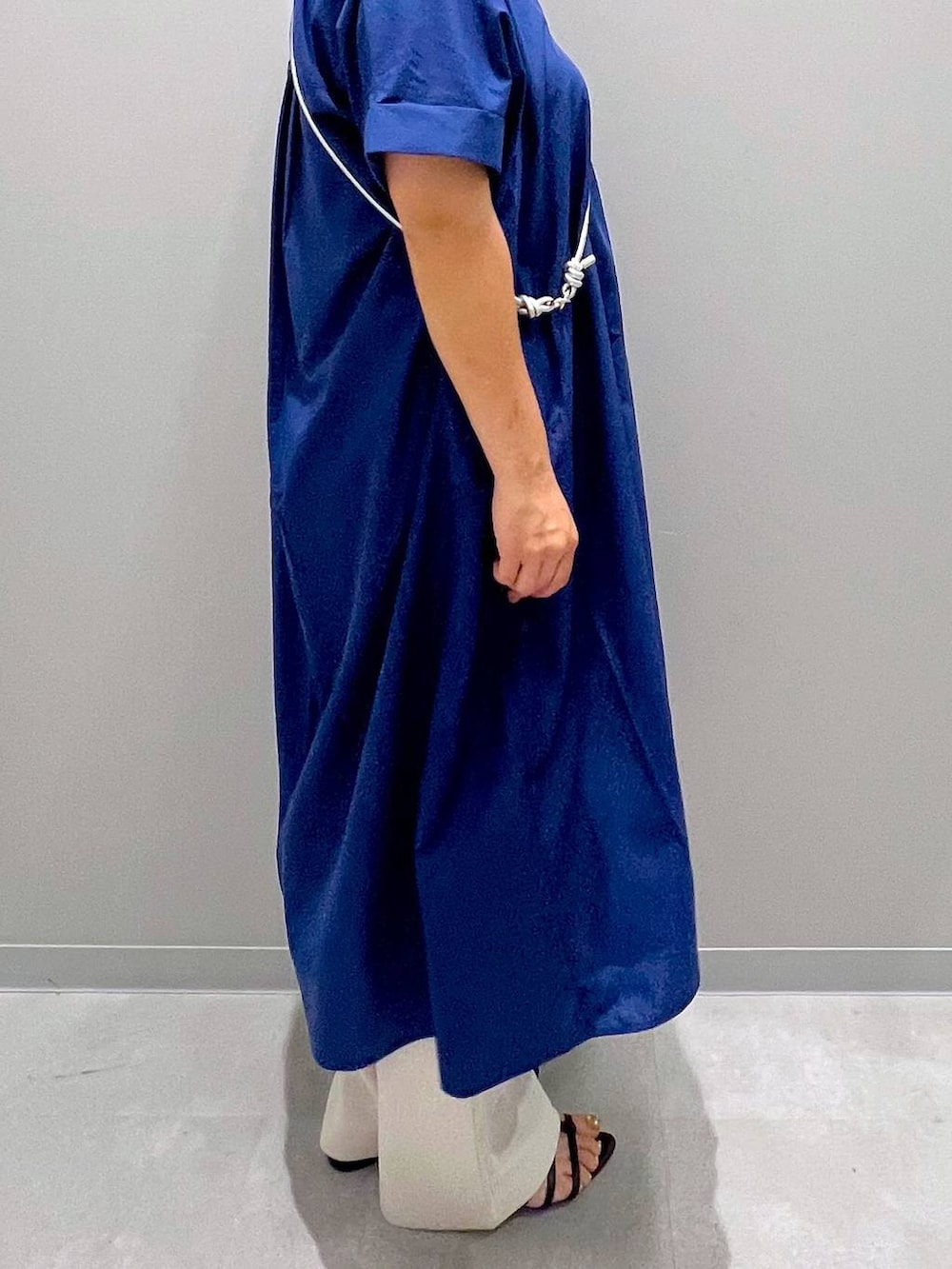 ブルー系のシャツワンピース、ホワイト系のその他パンツ、グレー系のスマホグッズを着用したレディースの夏コーディネートの4枚目の写真