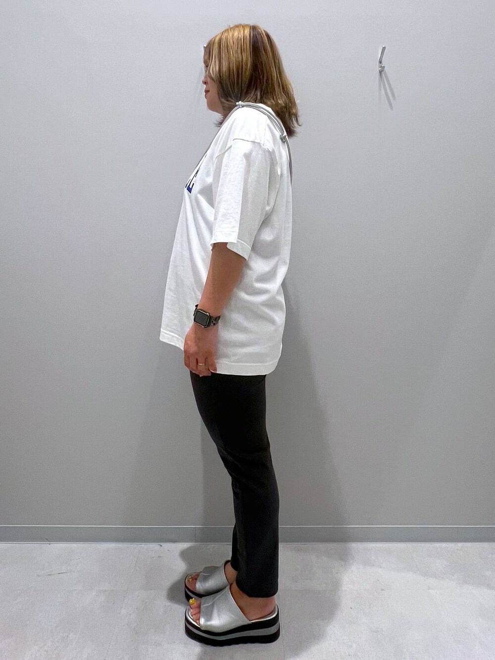 ブラック系のその他パンツ、ホワイト系のTシャツ/カットソー、グレー系のスマホグッズを着用したレディースの夏コーディネートの2枚目の写真