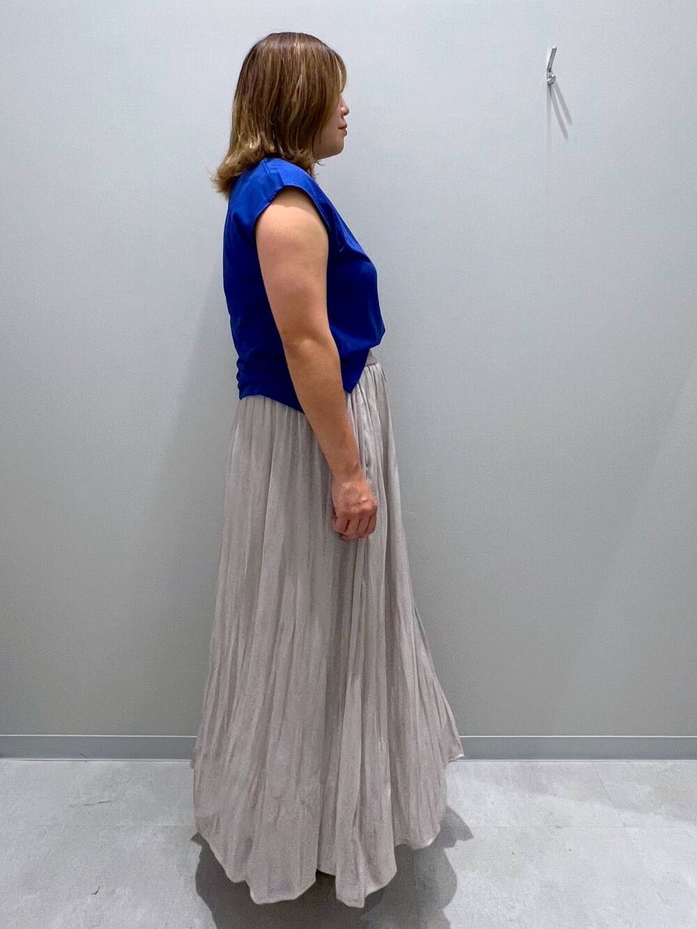 ベージュ系のスカート、ブルー系のタンクトップを着用したレディースの夏コーディネートの4枚目の写真