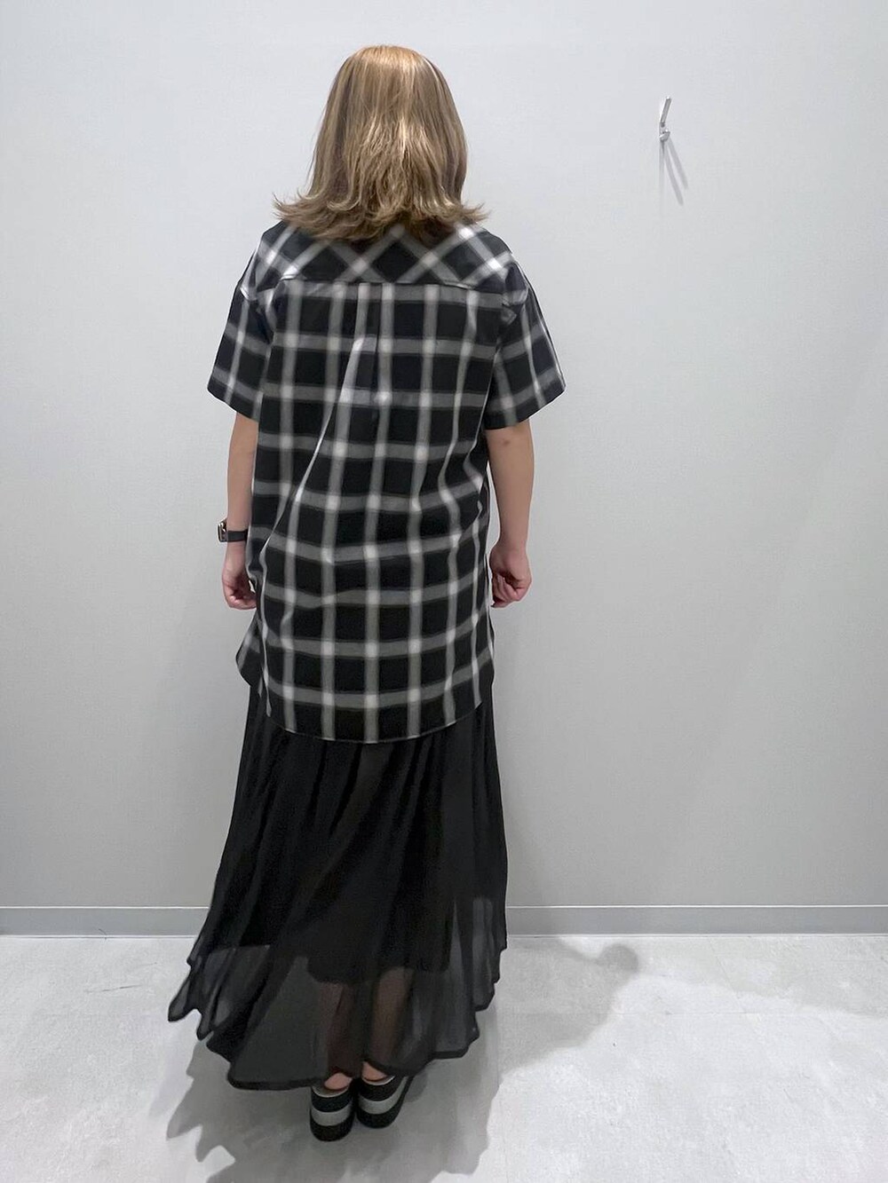 ブラック系のスカート、グレー系のシャツ/ブラウスを着用したレディースの夏コーディネートの3枚目の写真