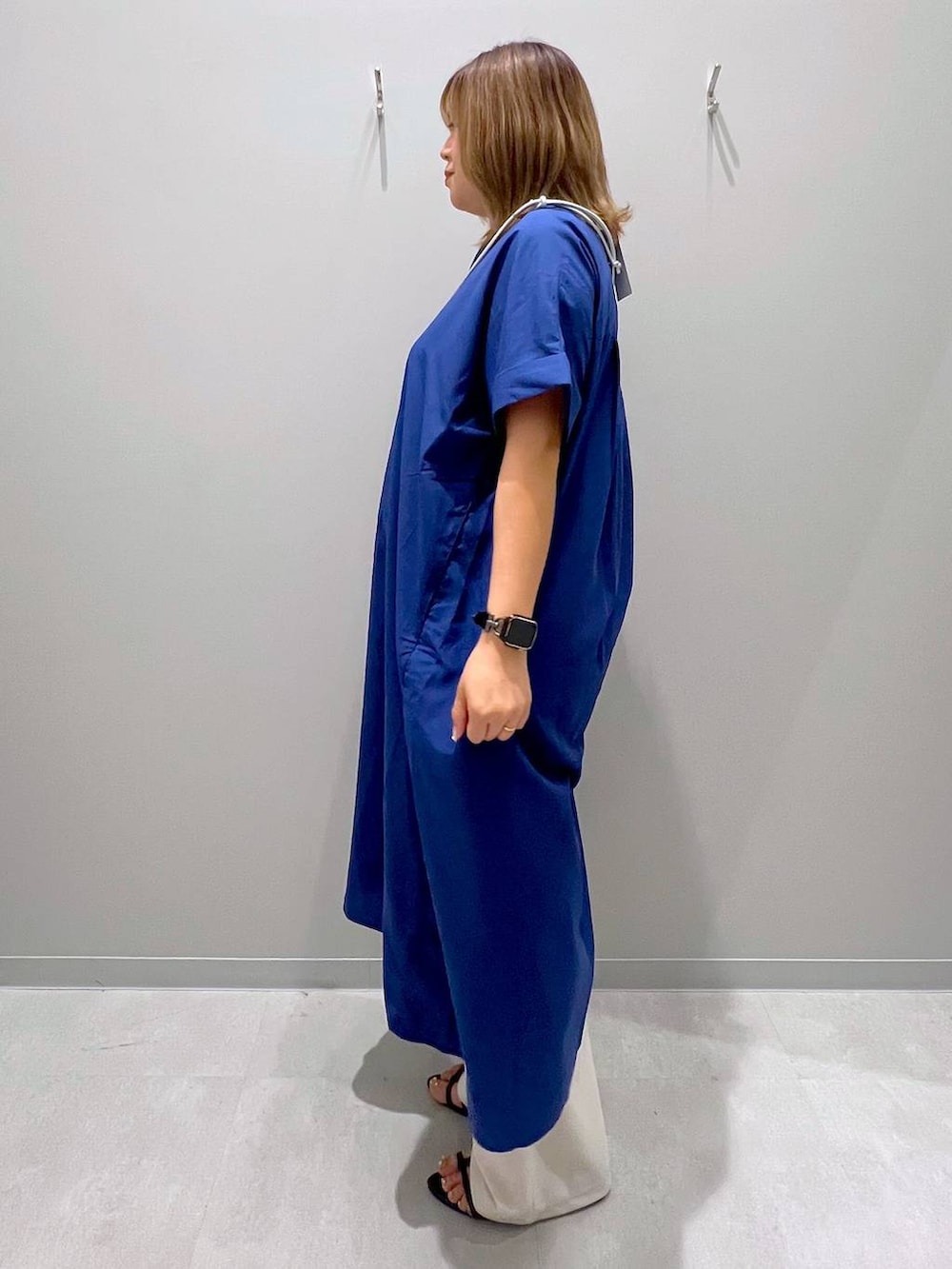ブルー系のシャツワンピース、ホワイト系のその他パンツ、グレー系のスマホグッズを着用したレディースの夏コーディネートの2枚目の写真
