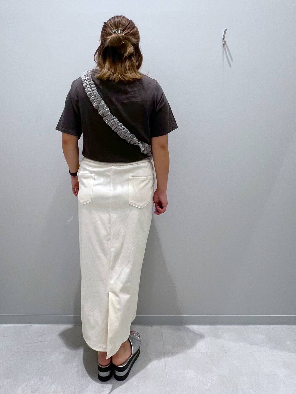 グレー系のTシャツ/カットソー、ホワイト系のデニムスカート、グレー系のスマホグッズを着用したレディースの夏コーディネートの3枚目の写真