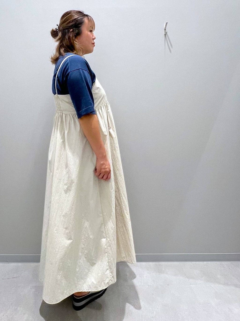 ブルー系のデニムパンツ、ホワイト系のワンピース、ブルー系のニット/セーターを着用したレディースの夏コーディネートの4枚目の写真