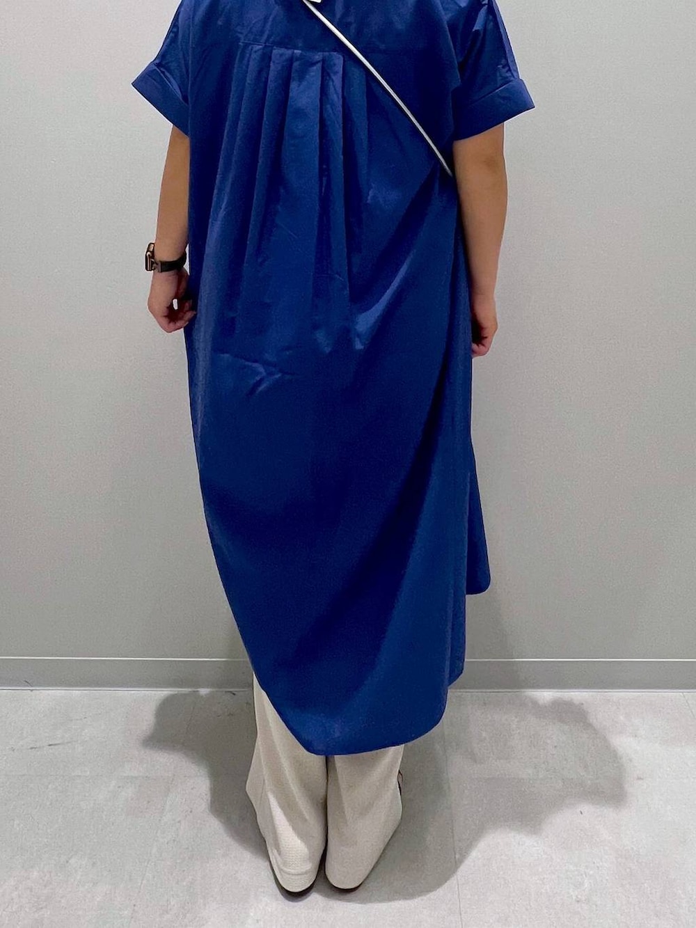 ブルー系のシャツワンピース、ホワイト系のその他パンツ、グレー系のスマホグッズを着用したレディースの夏コーディネートの3枚目の写真
