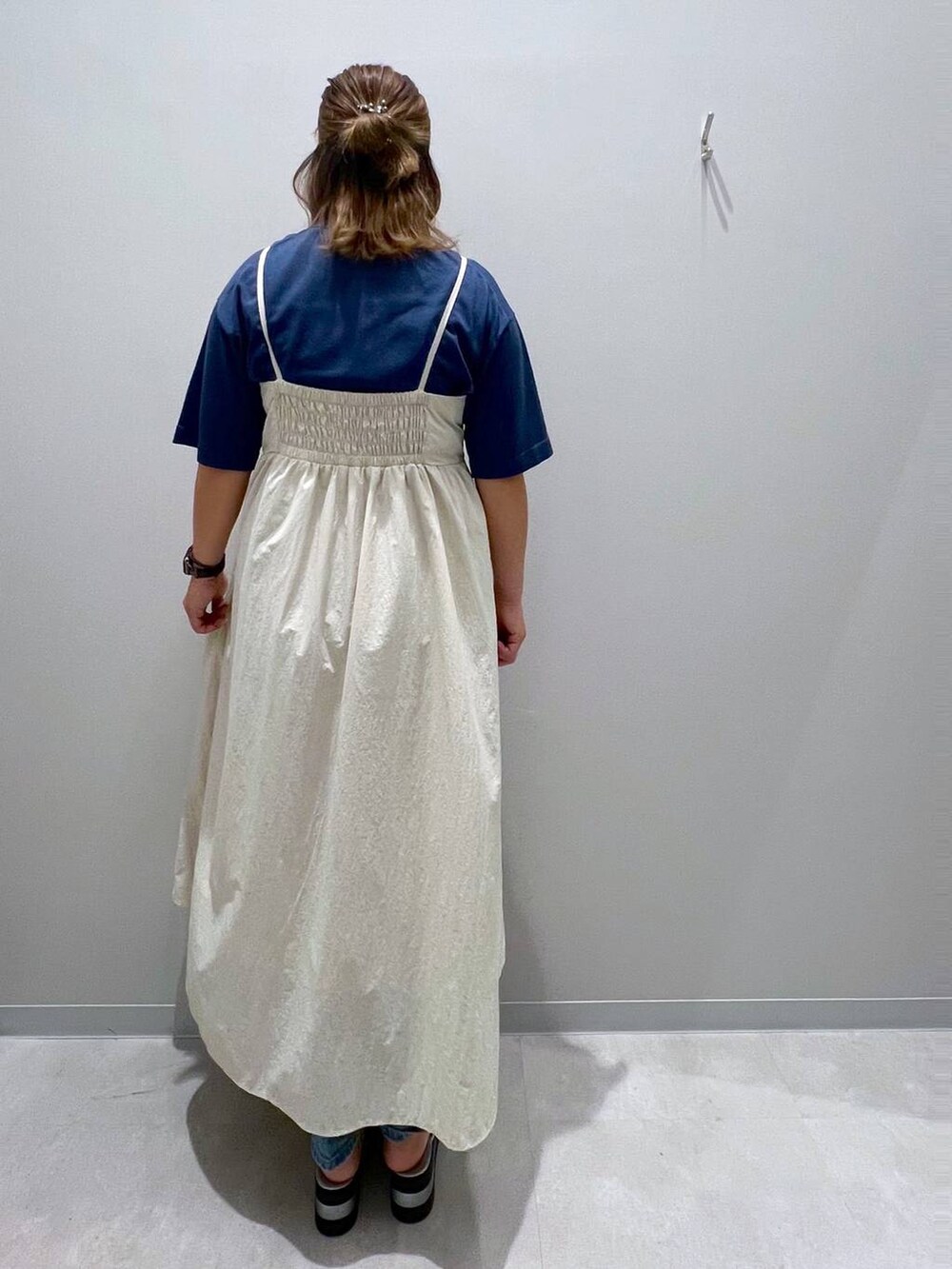 ブルー系のデニムパンツ、ホワイト系のワンピース、ブルー系のニット/セーターを着用したレディースの夏コーディネートの3枚目の写真