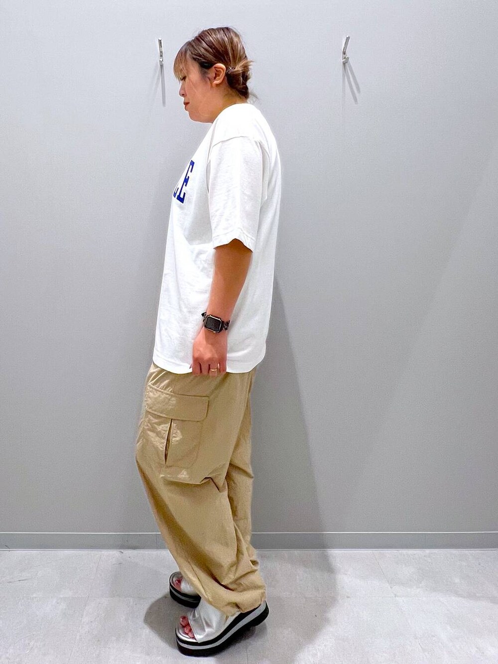ベージュ系のカーゴパンツ、ホワイト系のTシャツ/カットソーを着用したレディースの夏コーディネートの2枚目の写真