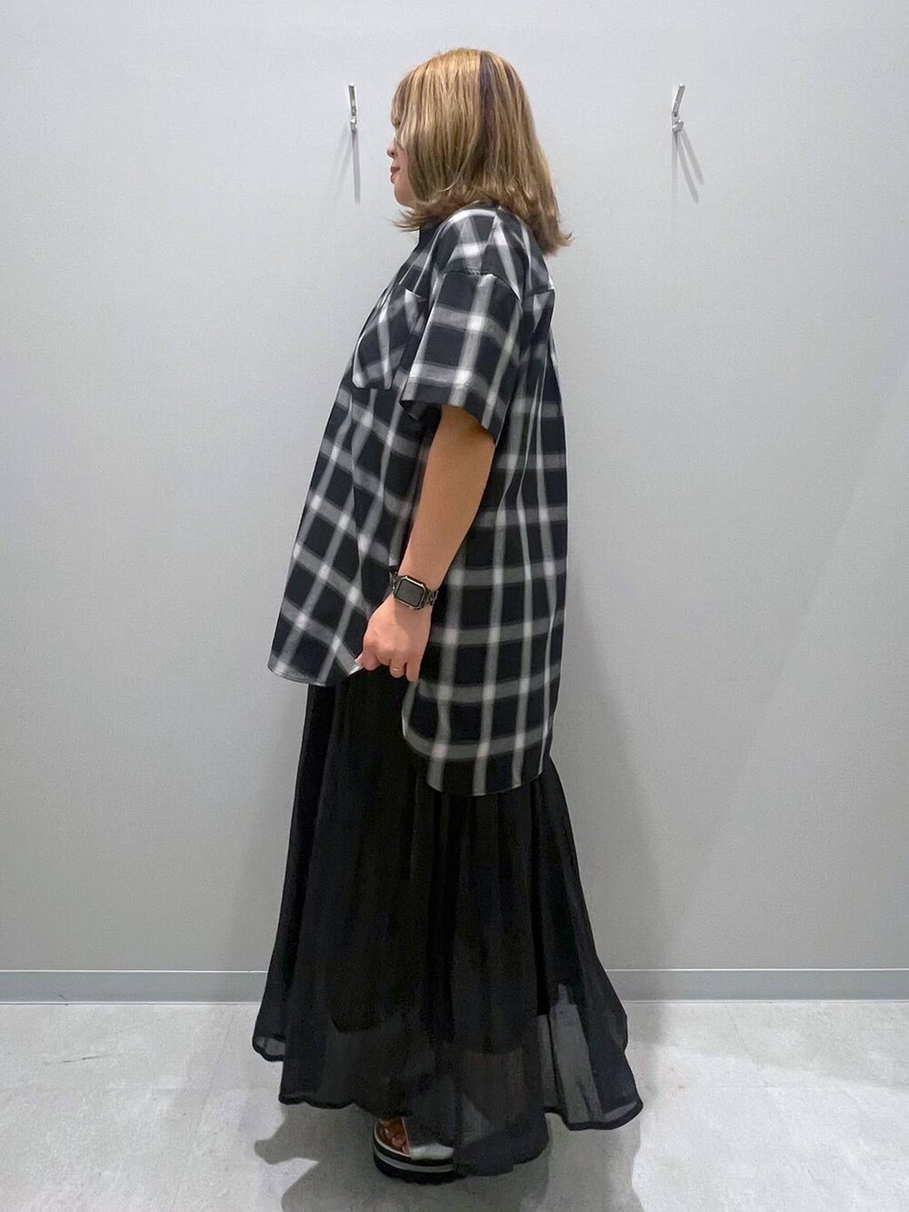 ブラック系のスカート、グレー系のシャツ/ブラウスを着用したレディースの夏コーディネートの2枚目の写真