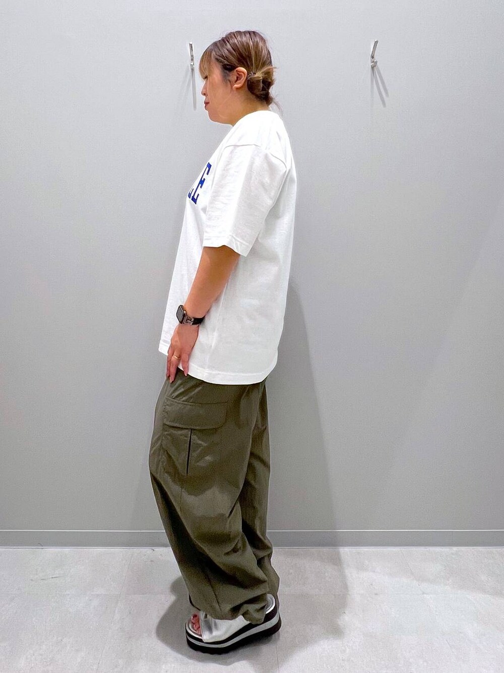 グリーン系のカーゴパンツ、ホワイト系のTシャツ/カットソーを着用したレディースの夏コーディネートの2枚目の写真