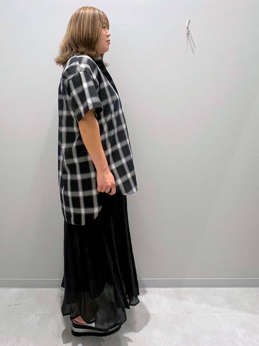 ブラック系のスカート、グレー系のシャツ/ブラウスを着用したレディースの夏コーディネートの4枚目の写真