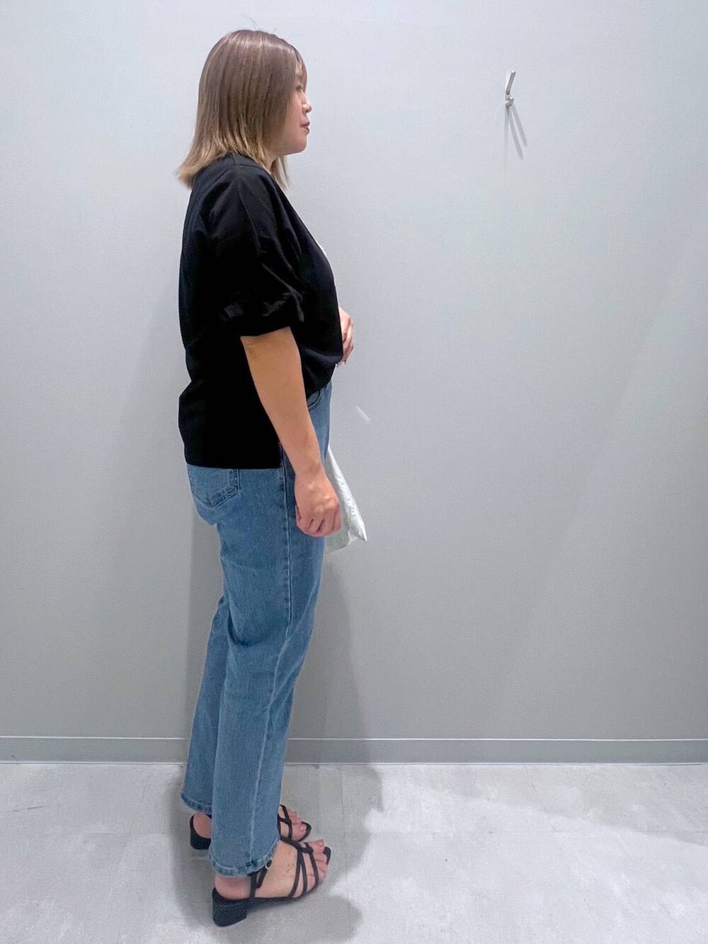 ブラック系のTシャツ/カットソー、ブルー系のデニムパンツ、ホワイト系のトートバッグを着用したレディースの夏コーディネートの4枚目の写真