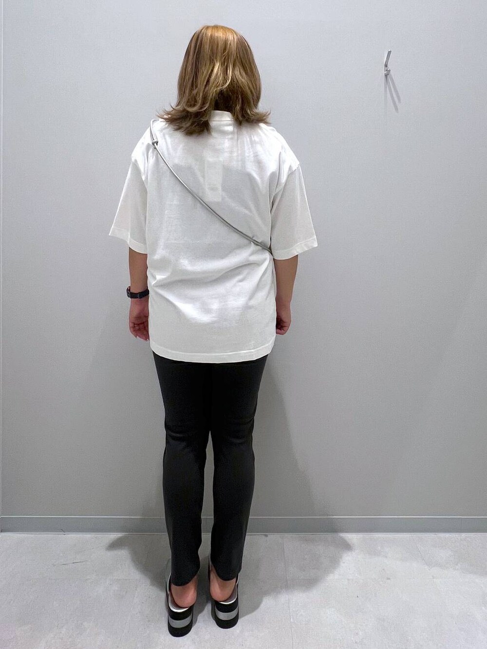 ブラック系のその他パンツ、ホワイト系のTシャツ/カットソー、グレー系のスマホグッズを着用したレディースの夏コーディネートの3枚目の写真