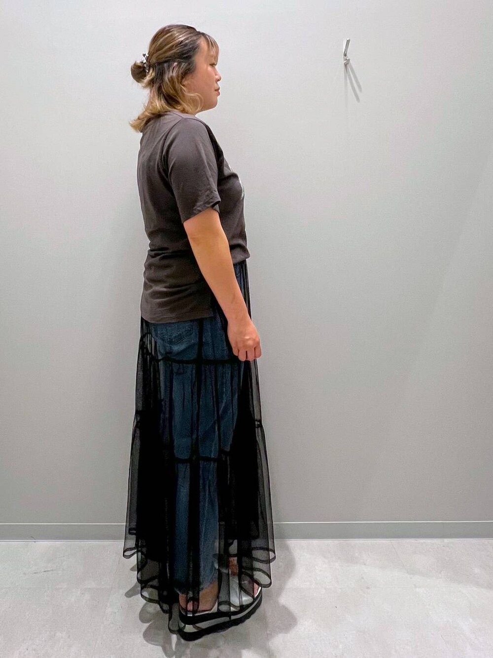 グレー系のTシャツ/カットソー、ブルー系のデニムパンツ、ブラック系のスカートを着用したレディースの夏コーディネートの4枚目の写真