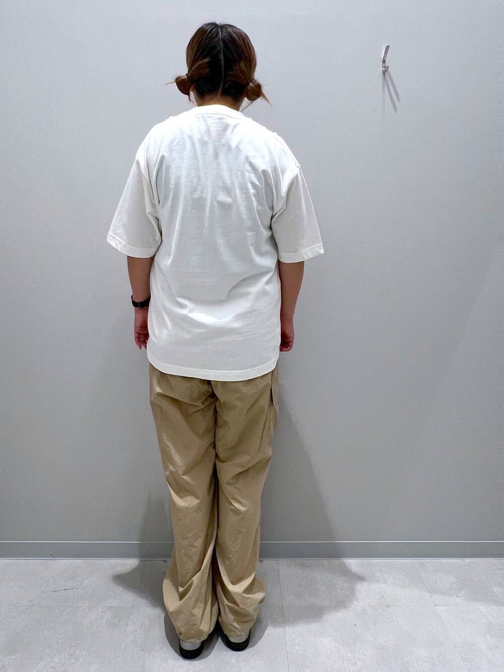 ベージュ系のカーゴパンツ、ホワイト系のTシャツ/カットソーを着用したレディースの夏コーディネートの3枚目の写真