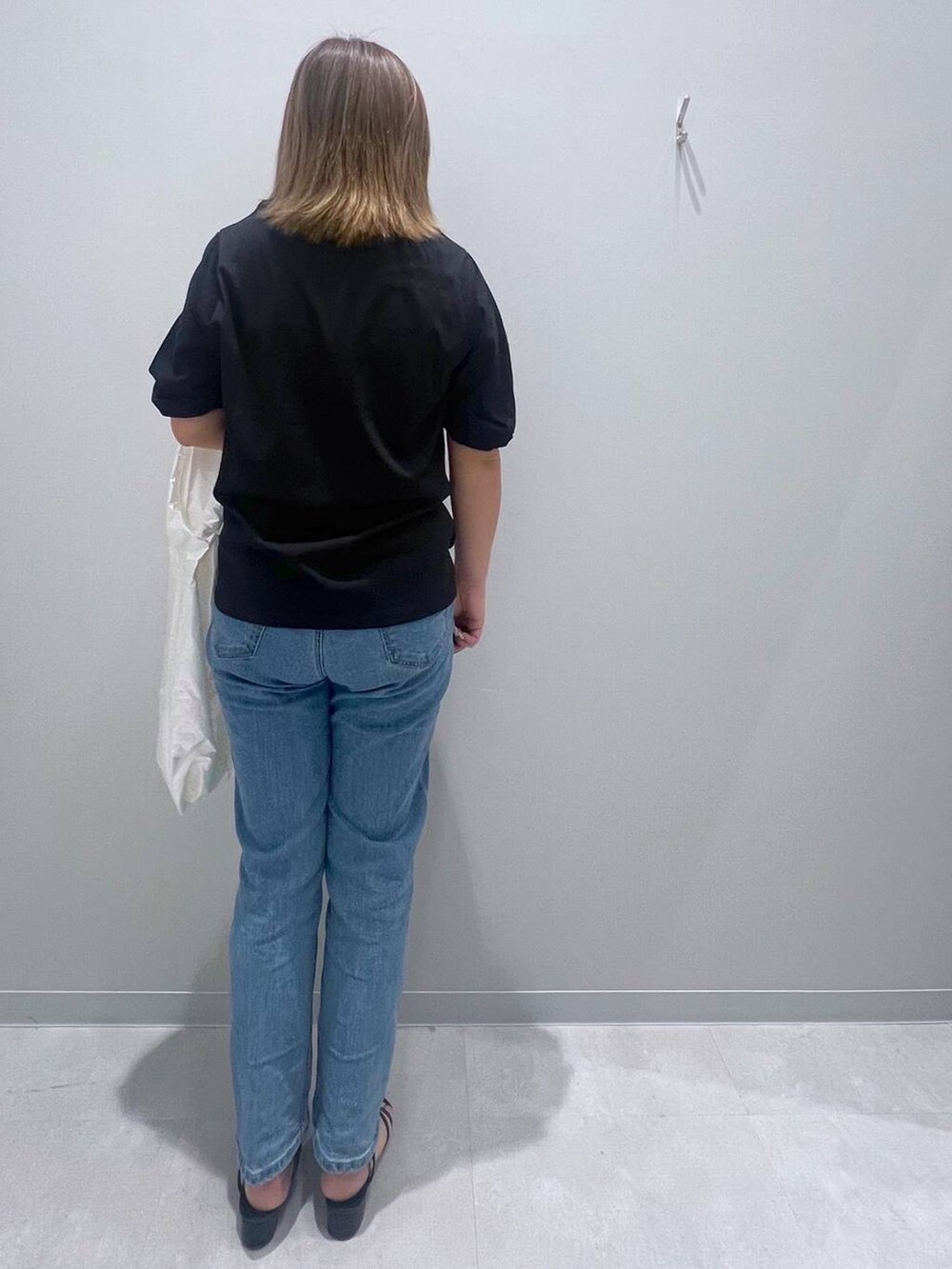 ブラック系のTシャツ/カットソー、ブルー系のデニムパンツ、ホワイト系のトートバッグを着用したレディースの夏コーディネートの3枚目の写真