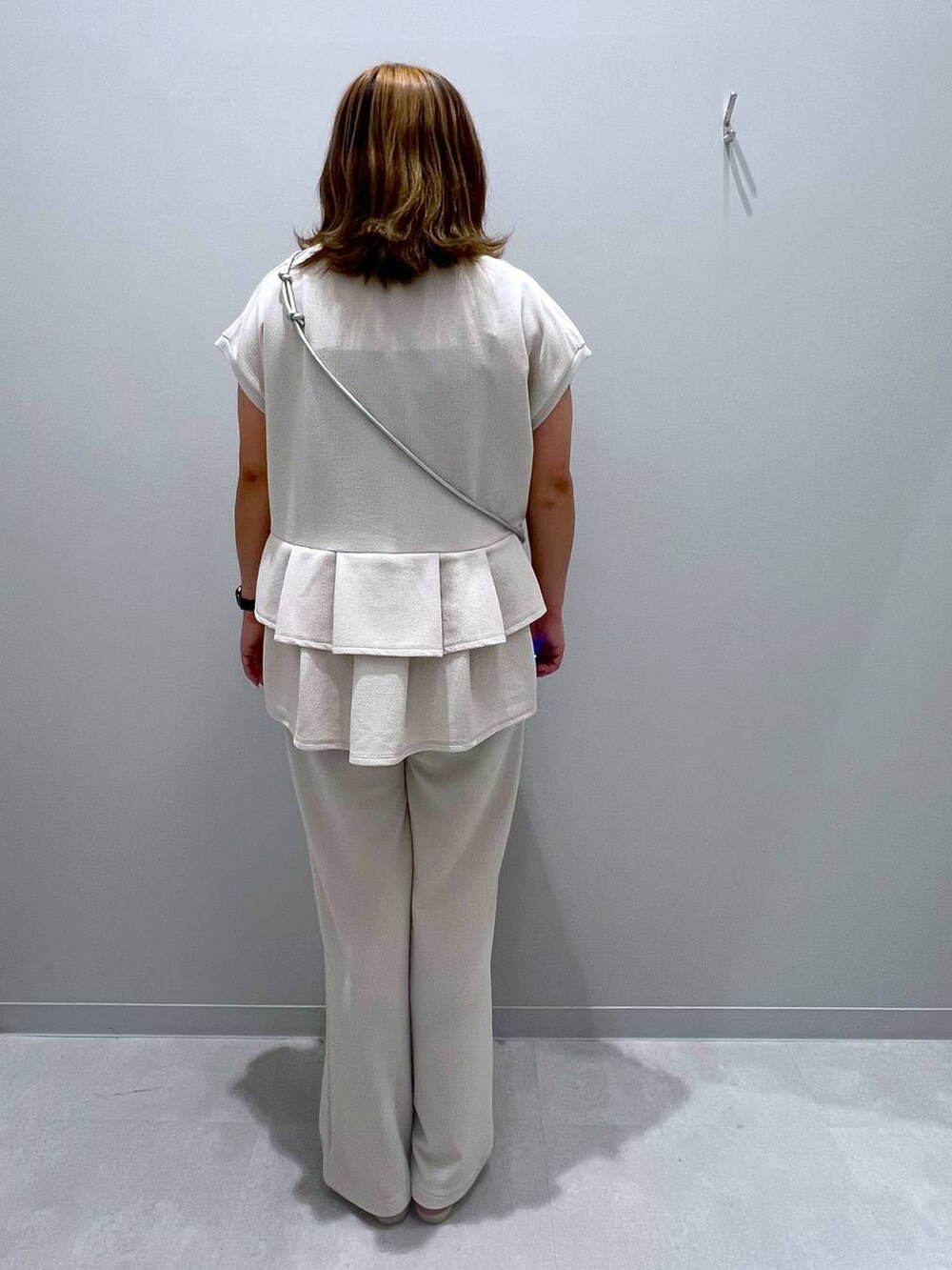 ホワイト系のTシャツ/カットソー、ホワイト系のその他パンツ、グレー系のスマホグッズを着用したレディースの夏コーディネートの3枚目の写真