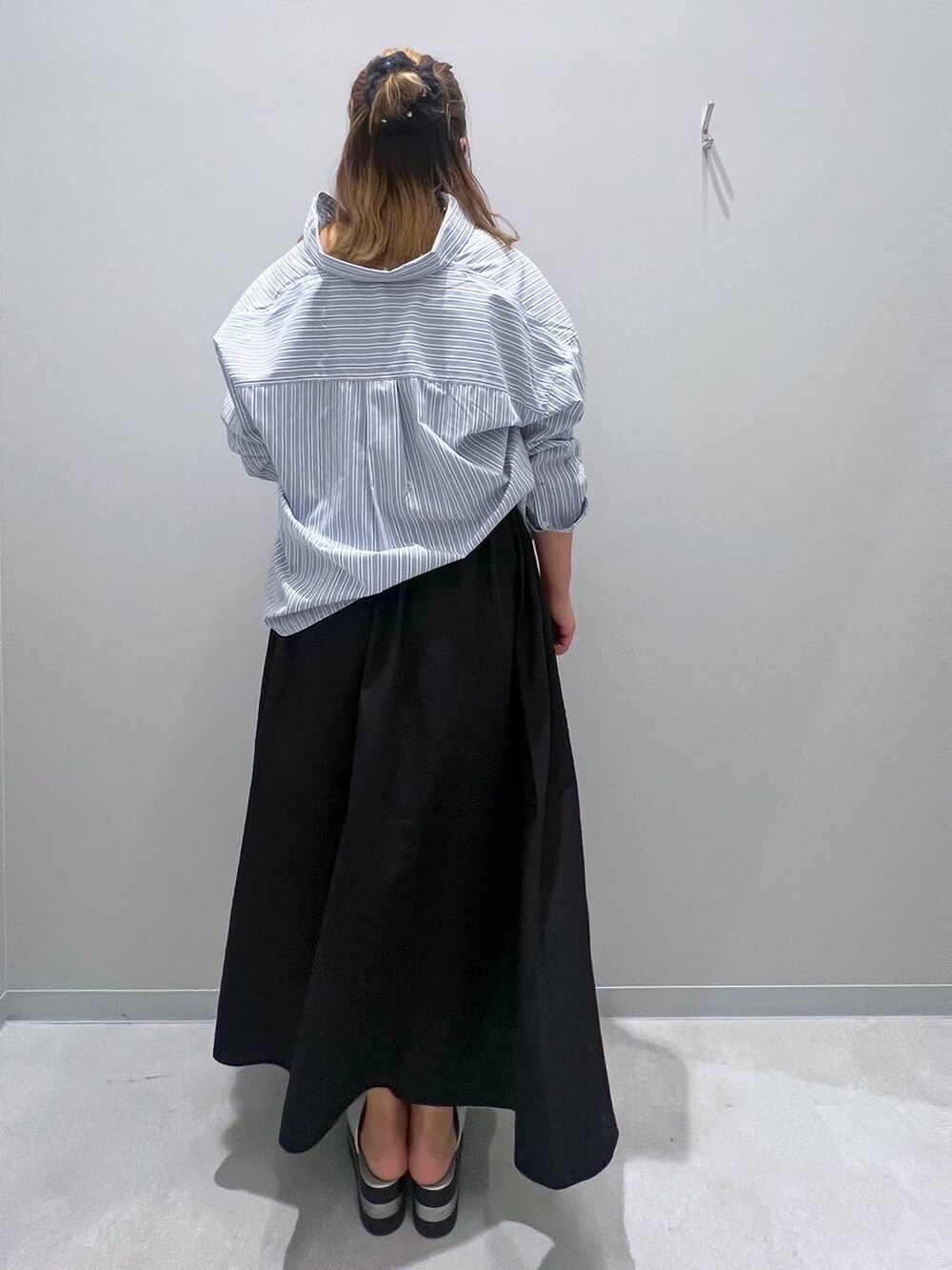 ブラック系のスカート、ブルー系のシャツ/ブラウスを着用したレディースの夏コーディネートの2枚目の写真