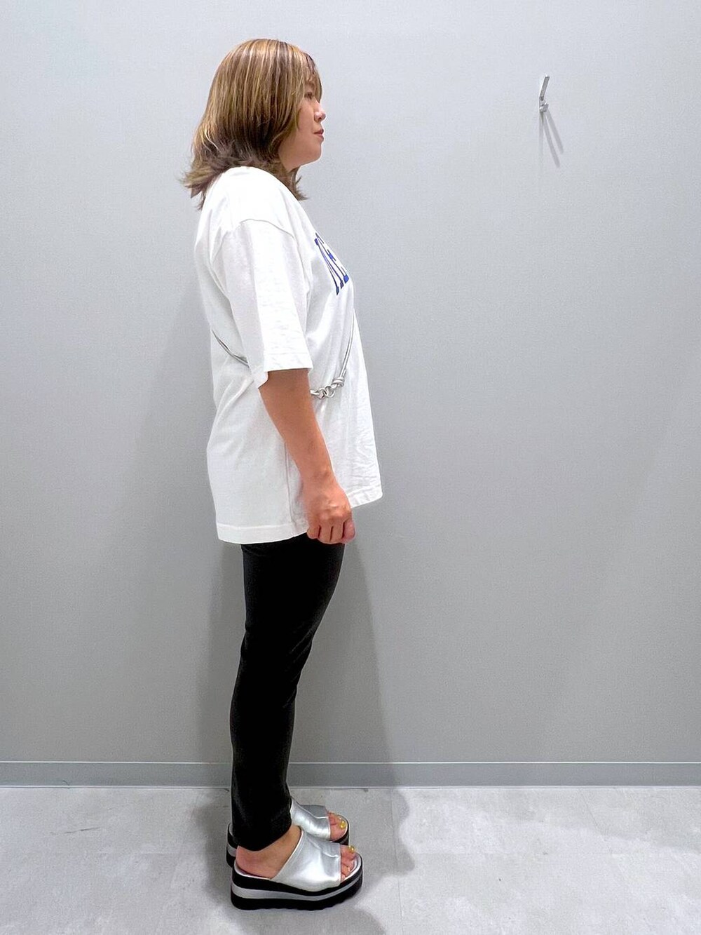 ブラック系のその他パンツ、ホワイト系のTシャツ/カットソー、グレー系のスマホグッズを着用したレディースの夏コーディネートの4枚目の写真