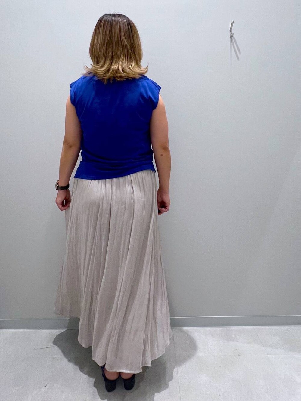 ベージュ系のスカート、ブルー系のタンクトップを着用したレディースの夏コーディネートの3枚目の写真