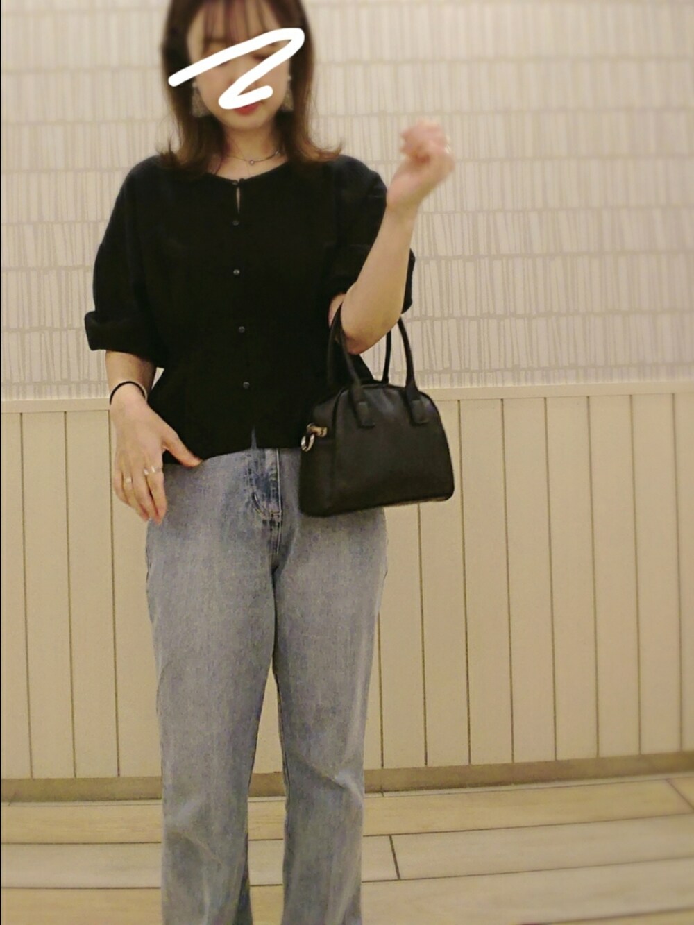 ブラック系のボストンバッグ、ブルー系のデニムパンツ、ブラック系のシャツ/ブラウスを着用したレディースの秋コーディネートの2枚目の写真