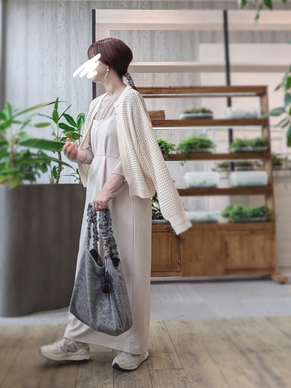 ベージュ系のスニーカー、ブラック系のハンドバッグ、ホワイト系のカーディガン/ボレロを着用したレディースの秋コーディネートの2枚目の写真