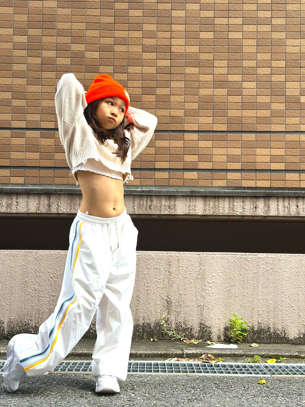 ホワイト系のスニーカー、ホワイト系のその他パンツ、ベージュ系のニット/セーターを着用したキッズの秋コーディネートの2枚目の写真