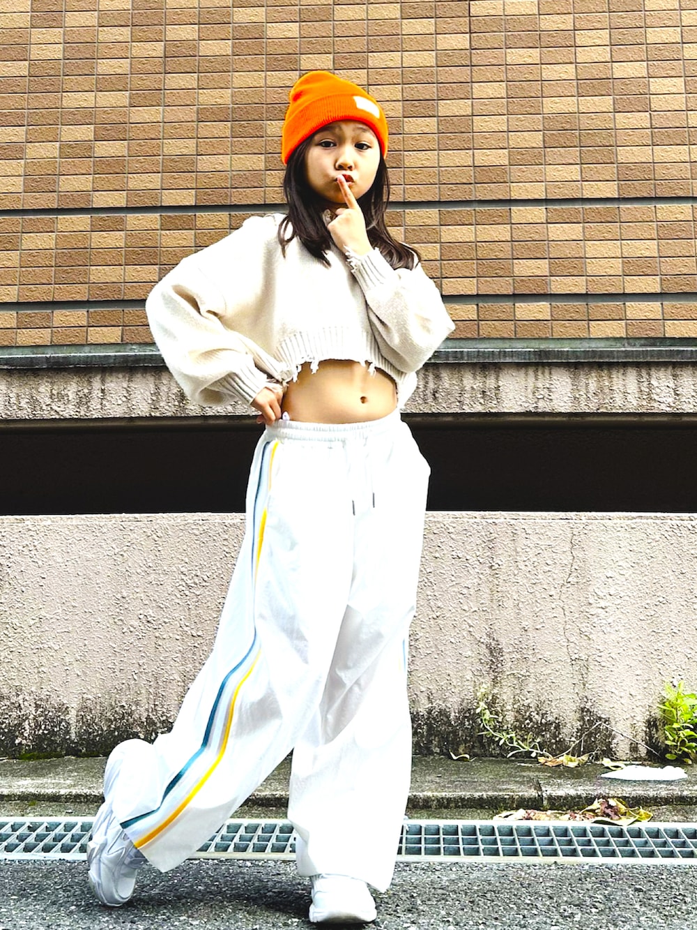 ホワイト系のスニーカー、ホワイト系のその他パンツ、ベージュ系のニット/セーターを着用したキッズの秋コーディネートの3枚目の写真