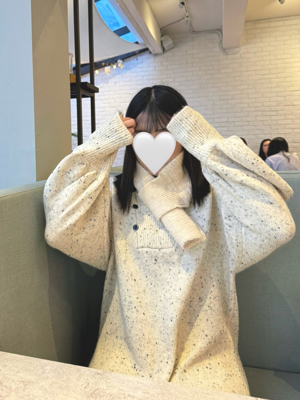 グレー系のスニーカー、ベージュ系のワンピース、ブラウン系のバッグを着用したレディースの冬コーディネートの3枚目の写真