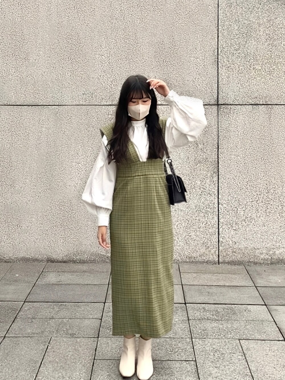 ホワイト系のシャツ/ブラウス、グリーン系のジャンパースカートを着用したレディースの冬コーディネートの2枚目の写真