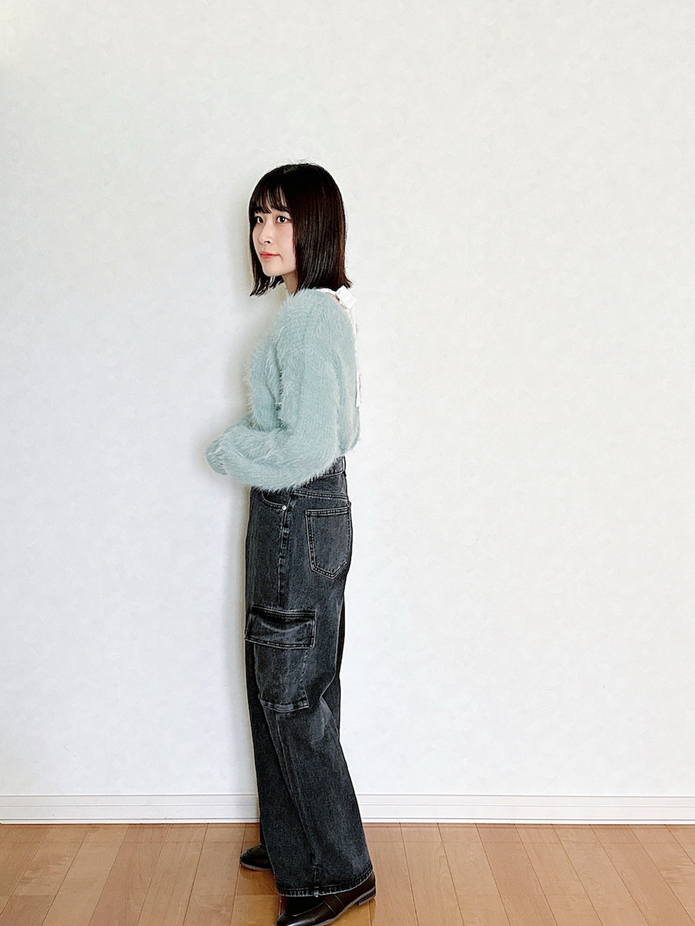 ブラック系のデニムパンツ、ブラウン系のローファー、ブラック系のニット/セーターを着用したレディースの秋コーディネートの2枚目の写真