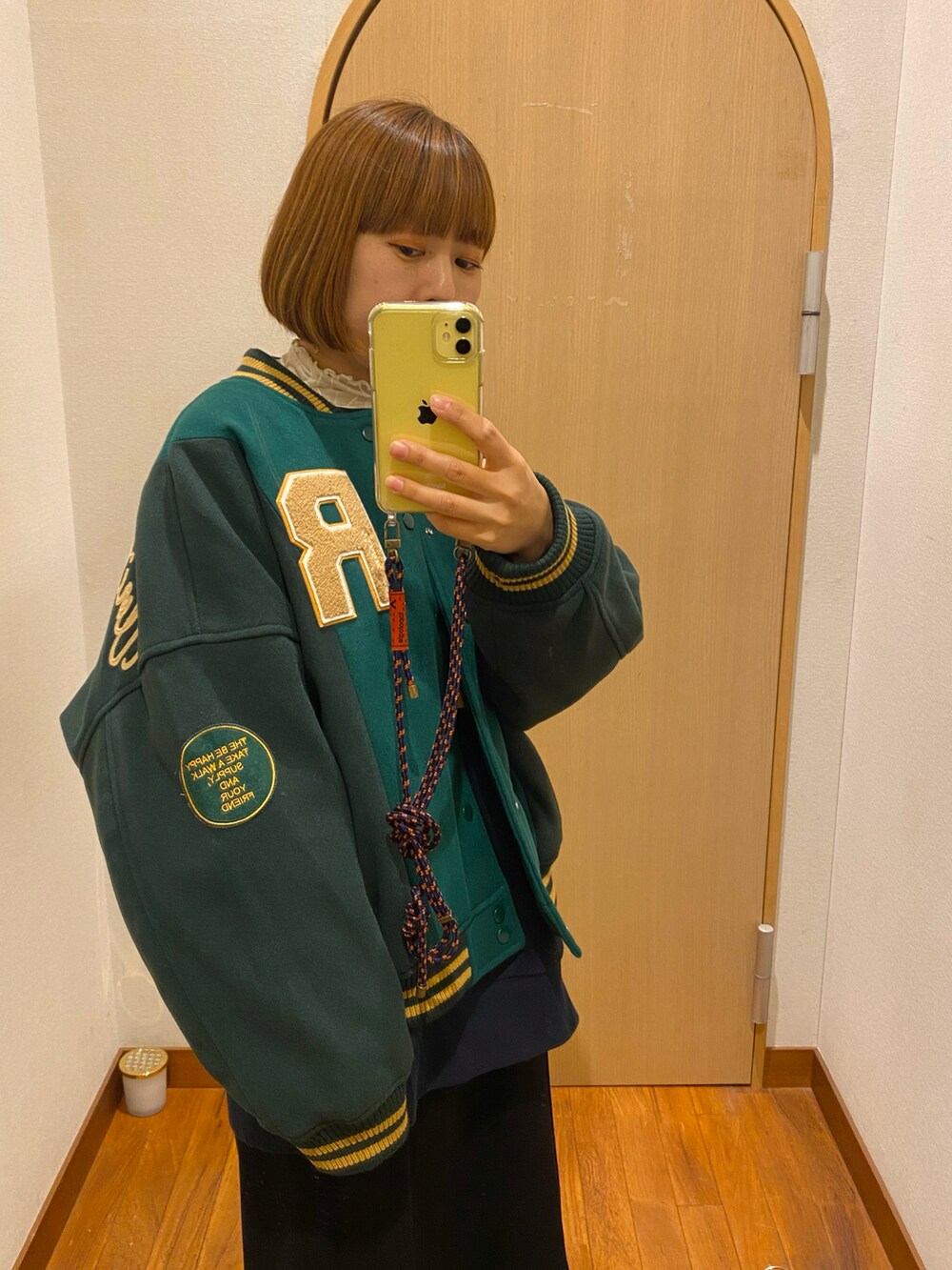 ホワイト系のスニーカー、ブルー系のスタジャンを着用したレディースの秋コーディネートの2枚目の写真