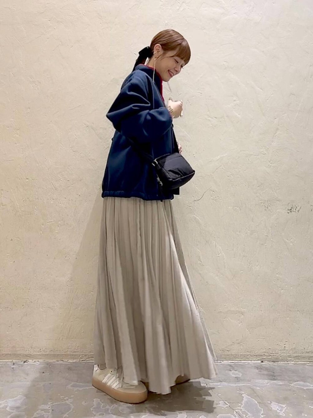 ブルー系のスウェット、ブラック系のショルダーバッグ、グレー系のスカートを着用したレディースの冬コーディネートの3枚目の写真