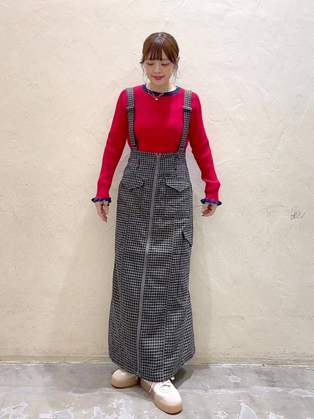 ブラック系のスカート、レッド系のニット/セーターを着用したレディースの秋コーディネートの2枚目の写真