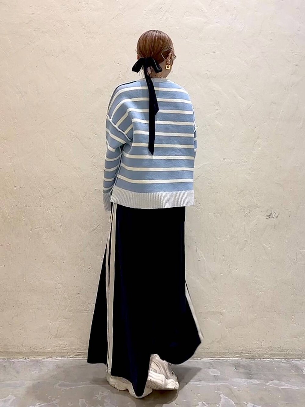 ホワイト系のTシャツ/カットソー、ブラック系のスカート、ベージュ系のニット/セーターを着用したレディースの冬コーディネートの5枚目の写真