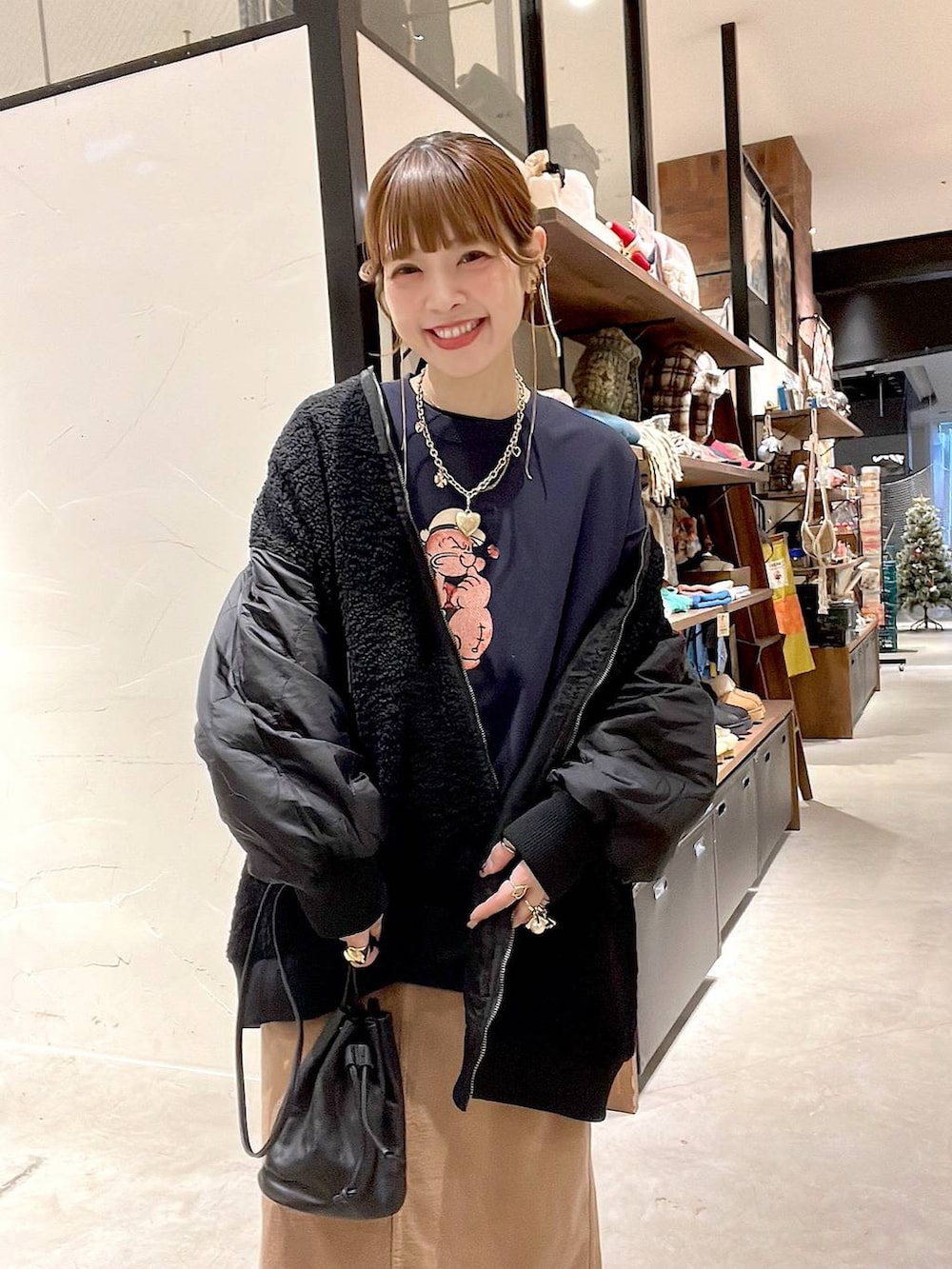 ブラック系のMA-1、イエロー系のスカート、ブルー系のスウェットを着用したレディースの冬コーディネートの6枚目の写真