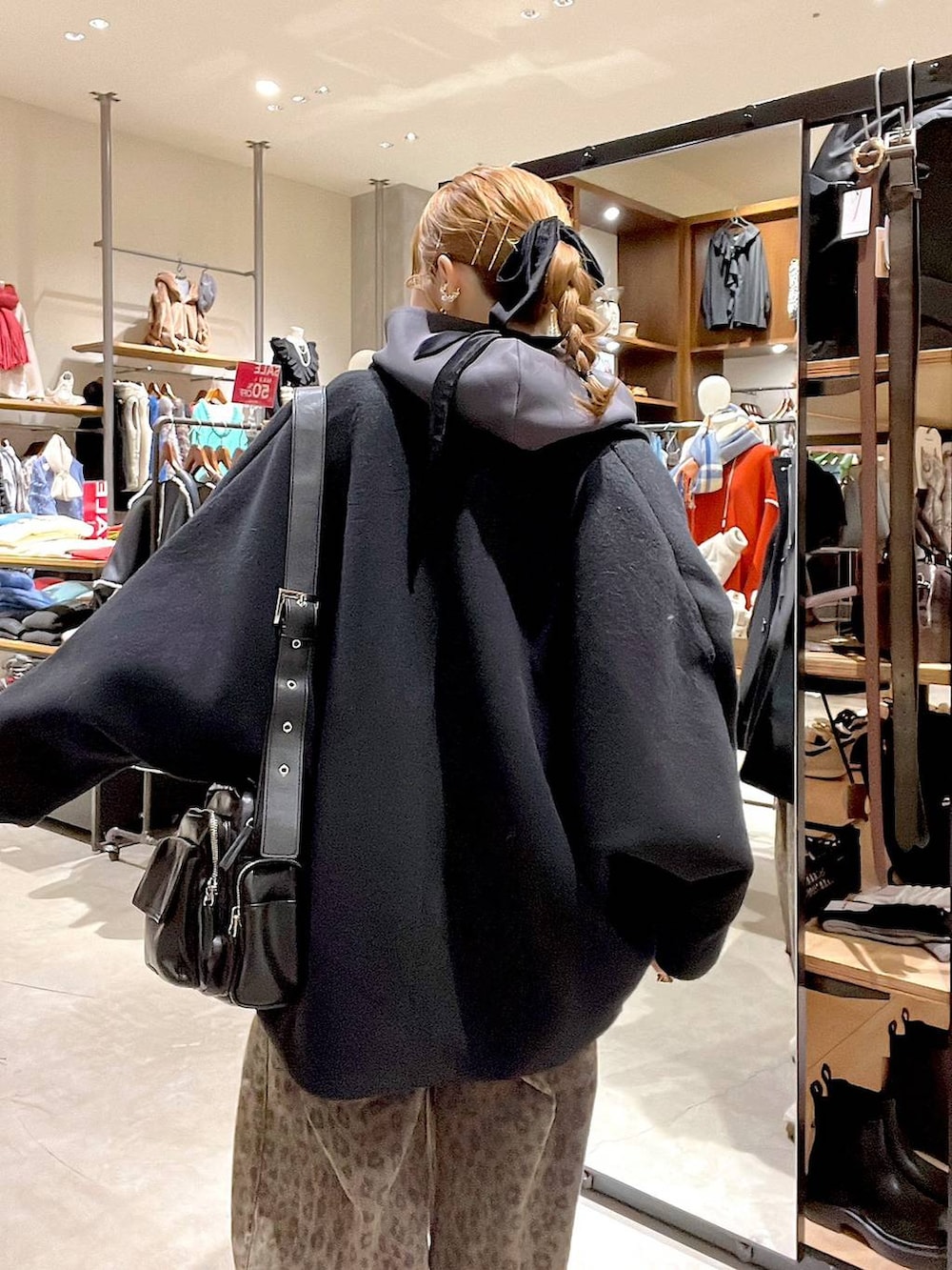 ブラック系のブルゾン、ブラウン系のデニムパンツ、ブラック系のショルダーバッグを着用したレディースの冬コーディネートの7枚目の写真