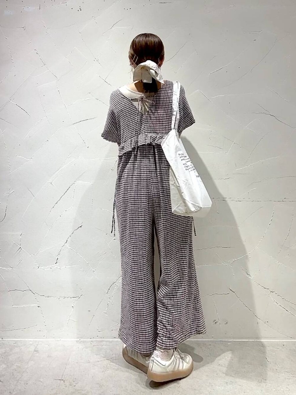 ベージュ系のトートバッグ、イエロー系のアナログ腕時計、ゴールド系のネックレスを着用したレディースの春コーディネートの5枚目の写真