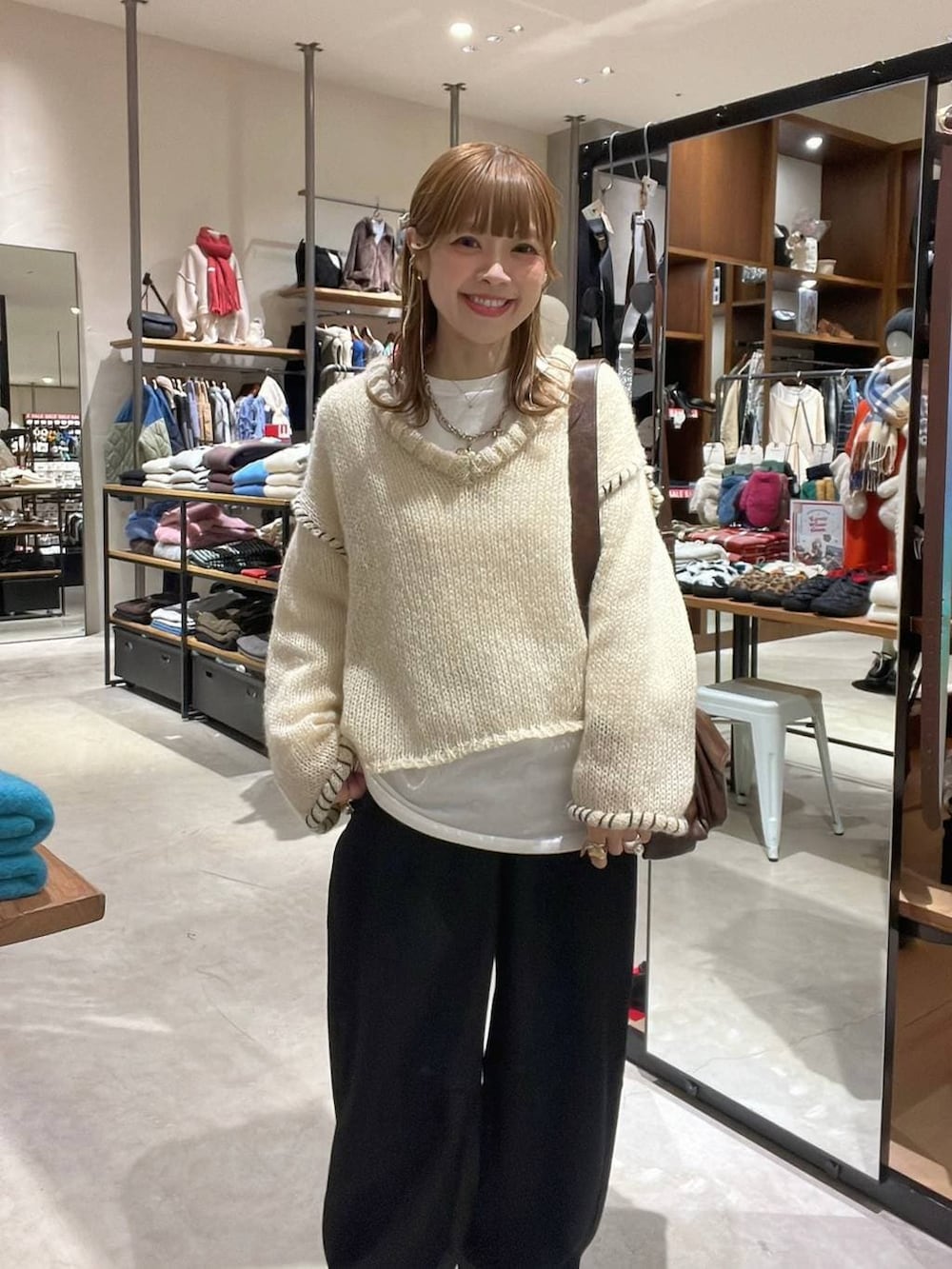 ホワイト系のTシャツ/カットソー、ブラウン系のショルダーバッグ、ベージュ系のスニーカーを着用したレディースの冬コーディネートの4枚目の写真