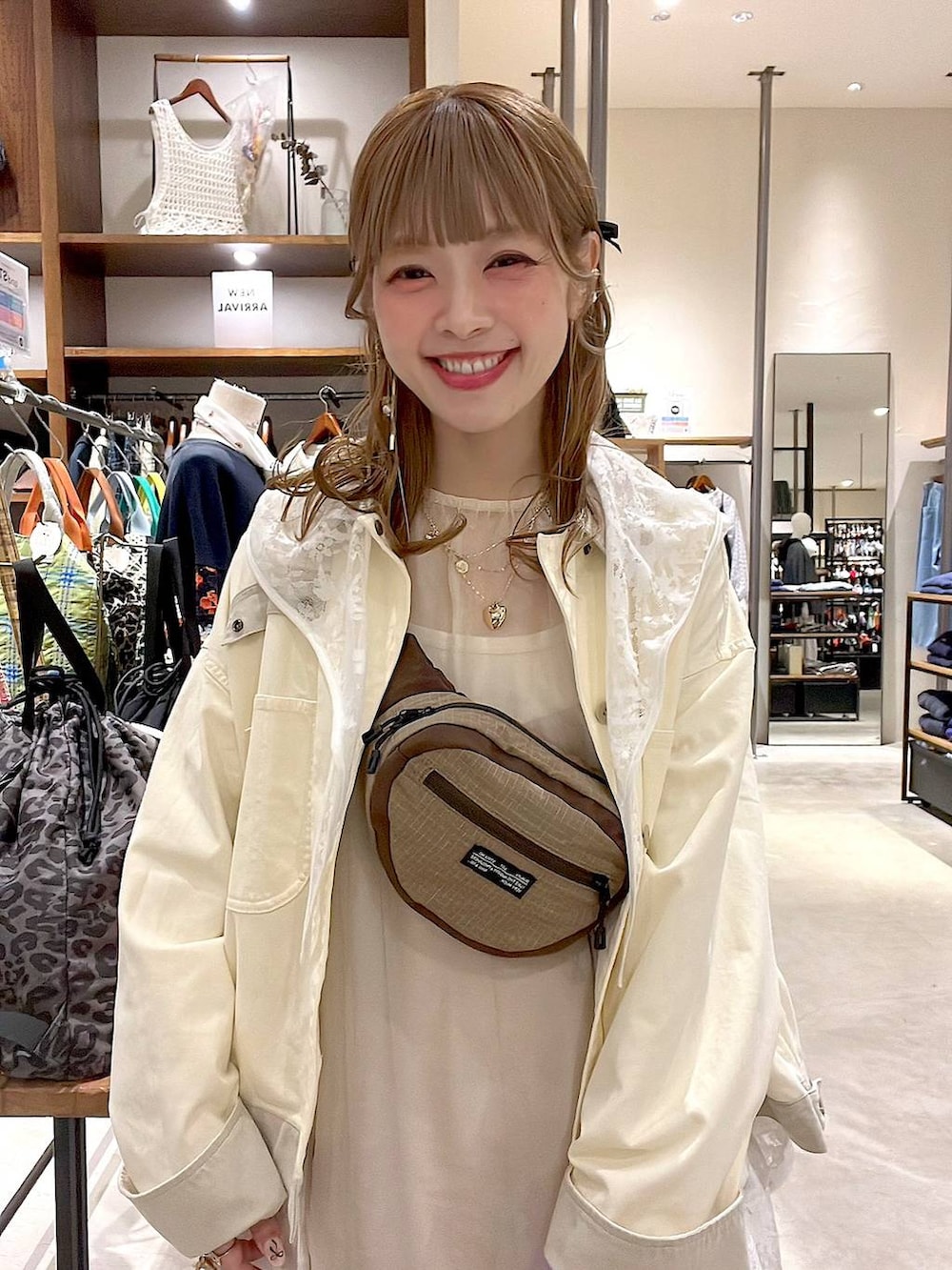 ホワイト系のベスト、ベージュ系のボディバッグ/ウエストポーチ、ホワイト系のブルゾンを着用したレディースの春コーディネートの4枚目の写真