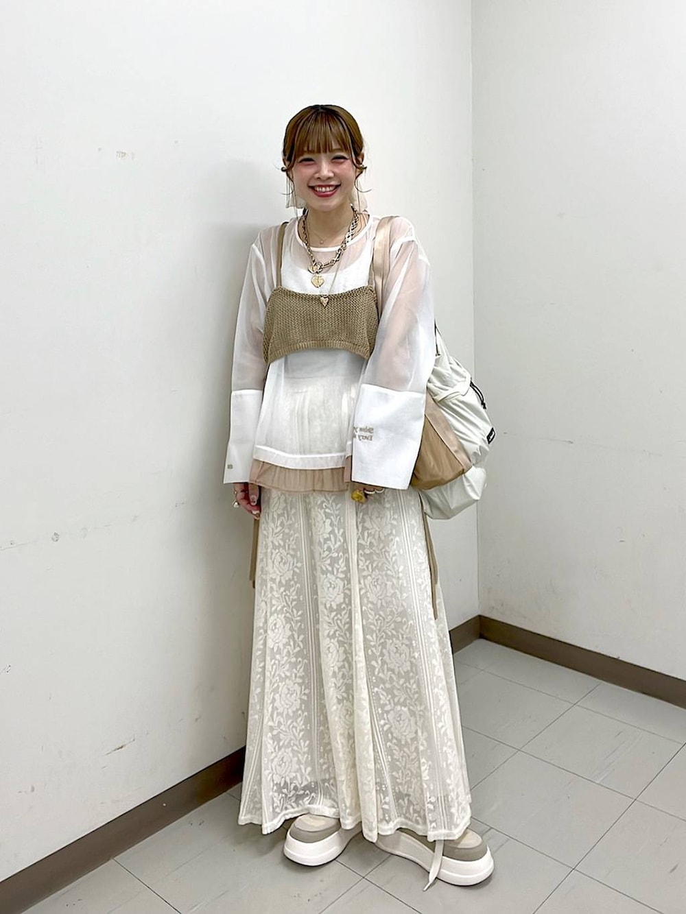 ベージュ系のスニーカー、ベージュ系のトートバッグ、ベージュ系のスカートを着用したレディースの冬コーディネートの3枚目の写真