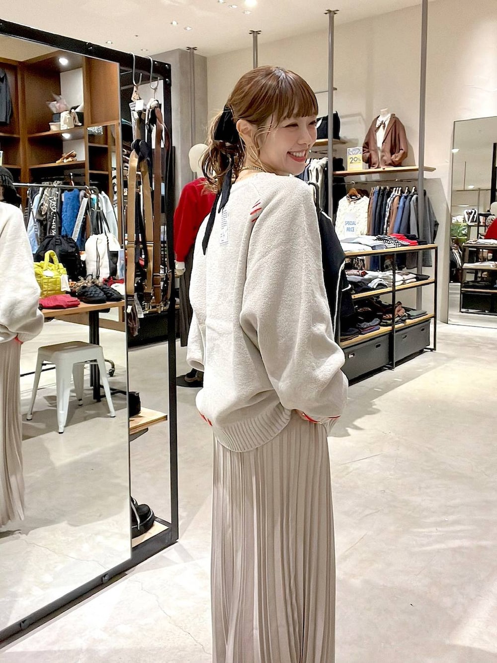 ベージュ系のスカート、ベージュ系のショルダーバッグ、イエロー系のネックレスを着用したレディースの秋コーディネートの4枚目の写真