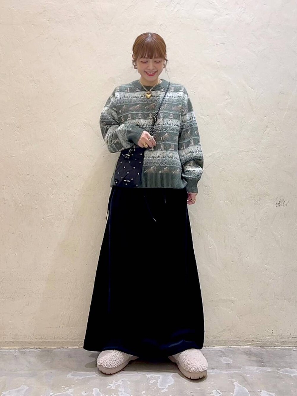 ブラック系のショルダーバッグ、ベージュ系のスリッポン、ブラック系のスカートを着用したレディースの冬コーディネートの8枚目の写真